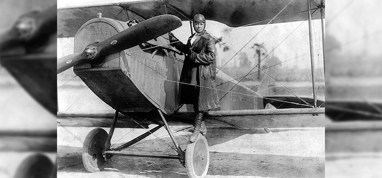 Bessie Coleman standing on her plane in 1922