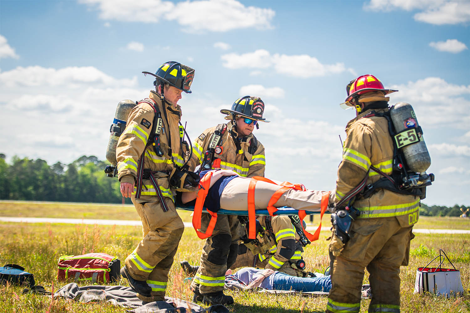 Fireman carrying injured person on stretcher during Auburn Aviation disaster drill
