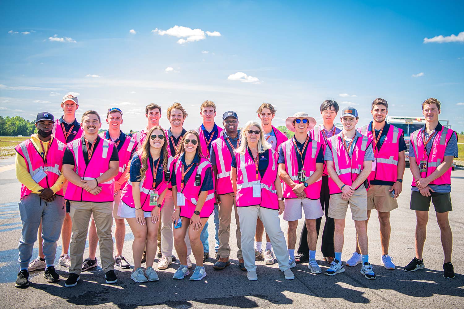 Auburn aviation students posing for group photo all in matching bright pink safety vests
