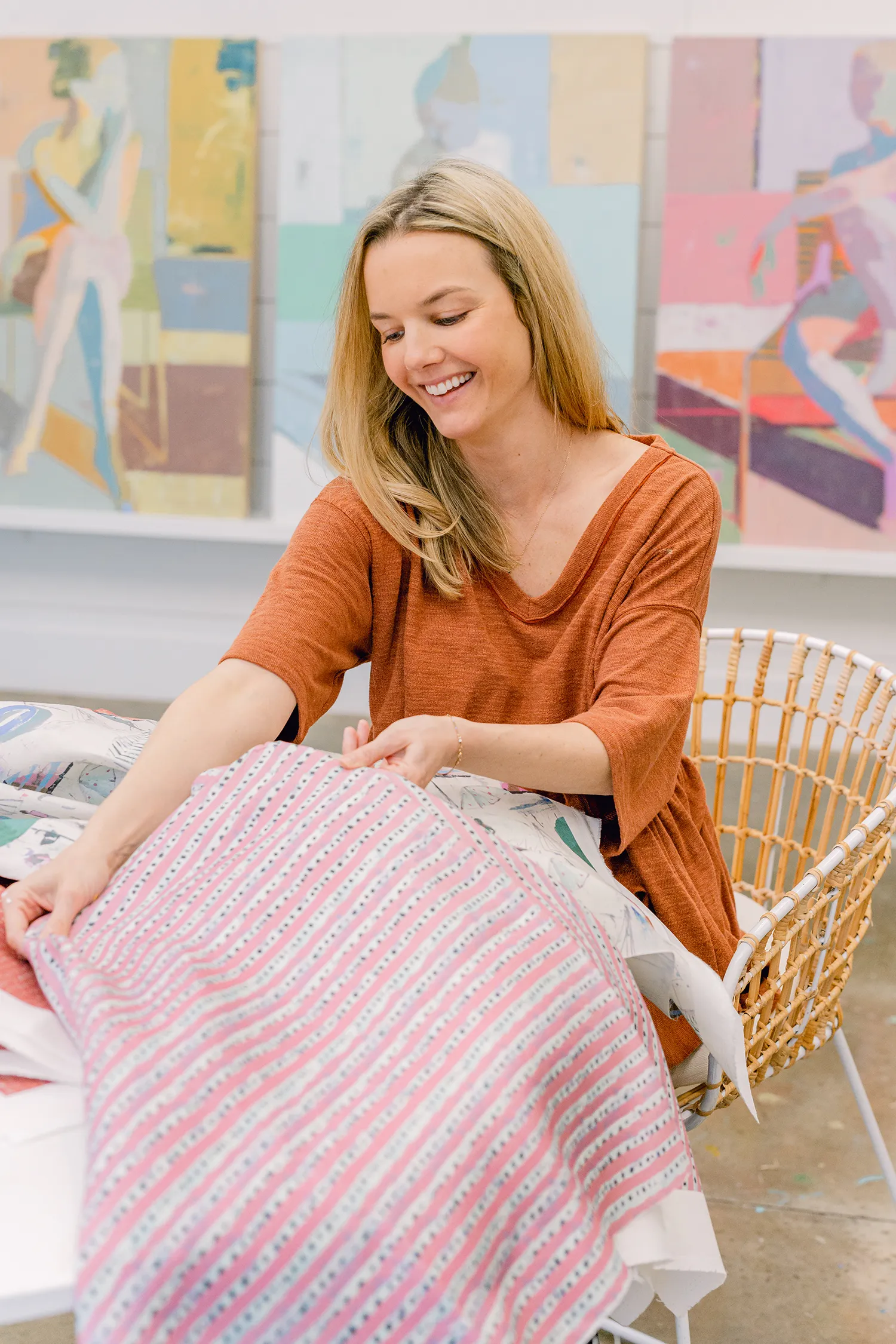 Teil Henly smiling and inspecting patterned textile