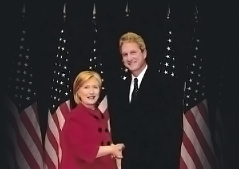 Alex Moore and Hilary Clinton posing for picture with flags in background