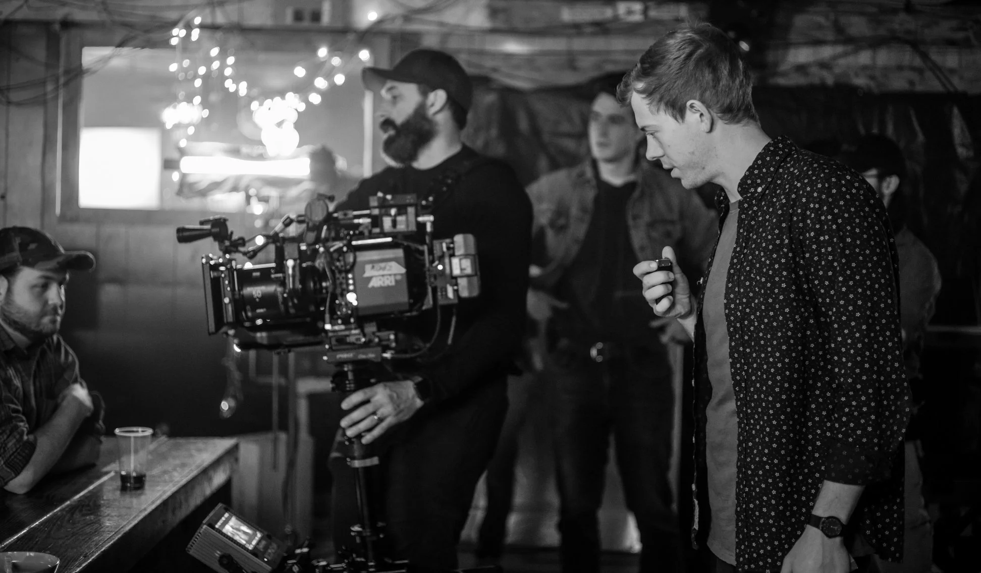 Black and white image of Brock directing with camera crew