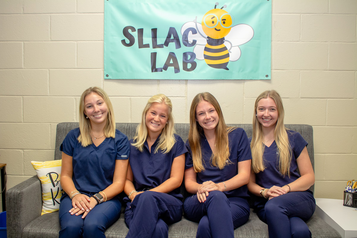 Group of Auburn student sitting on sofa in the SLLAC lab.