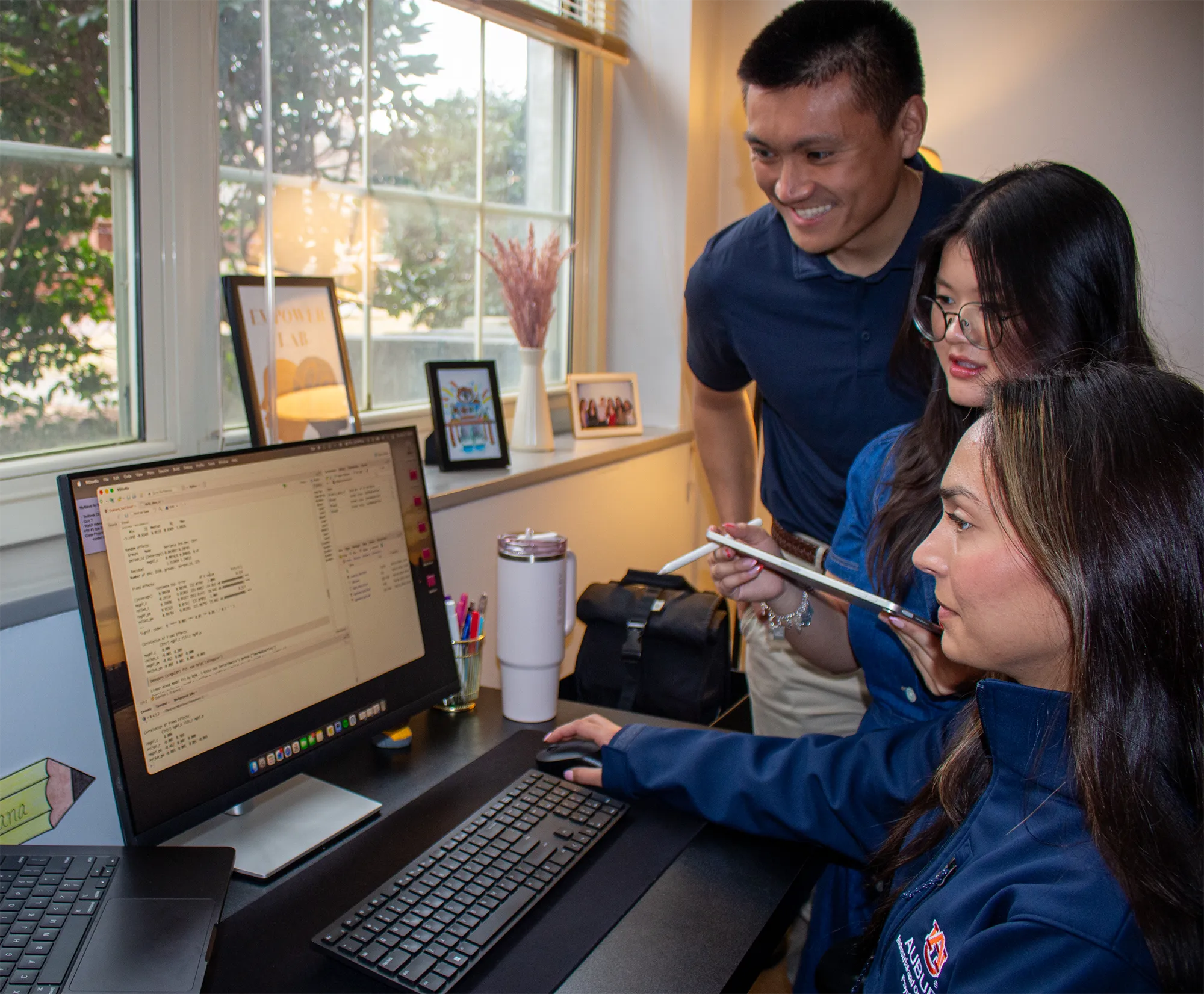 Three I/O graduate students looking at data on computer screens. 
